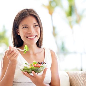 Woman smiling while eating healthy lunch outside