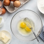 Whisk and cracked eggs