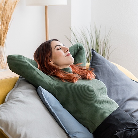 Woman smiling while relaxing on couch at home