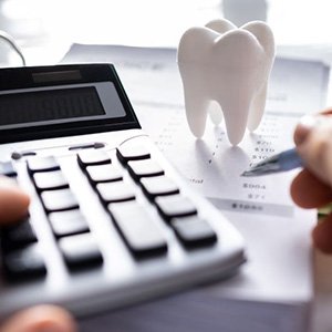 Person using calculator to budget for dental care